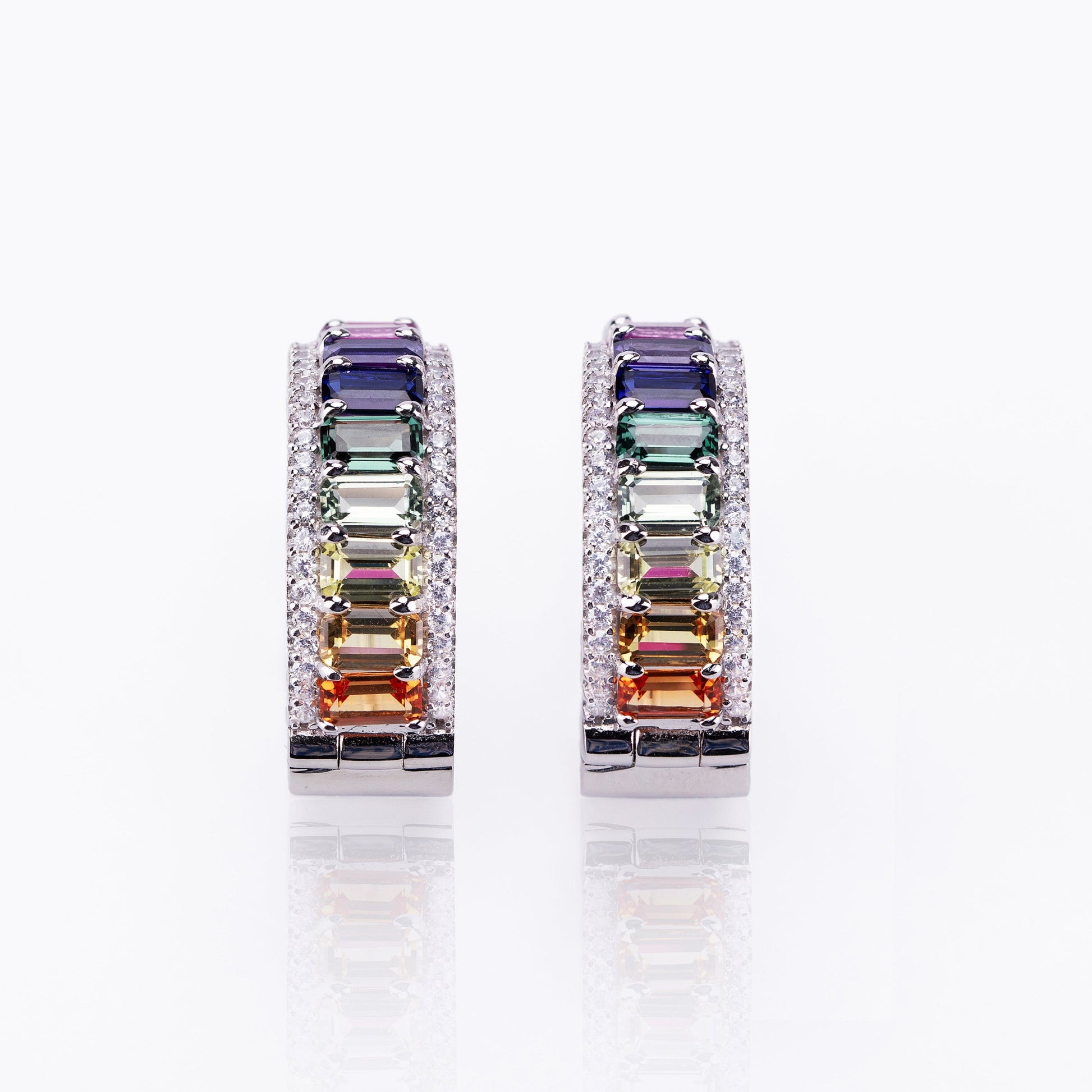 Pair of earrings with multicolored gemstones on a white background